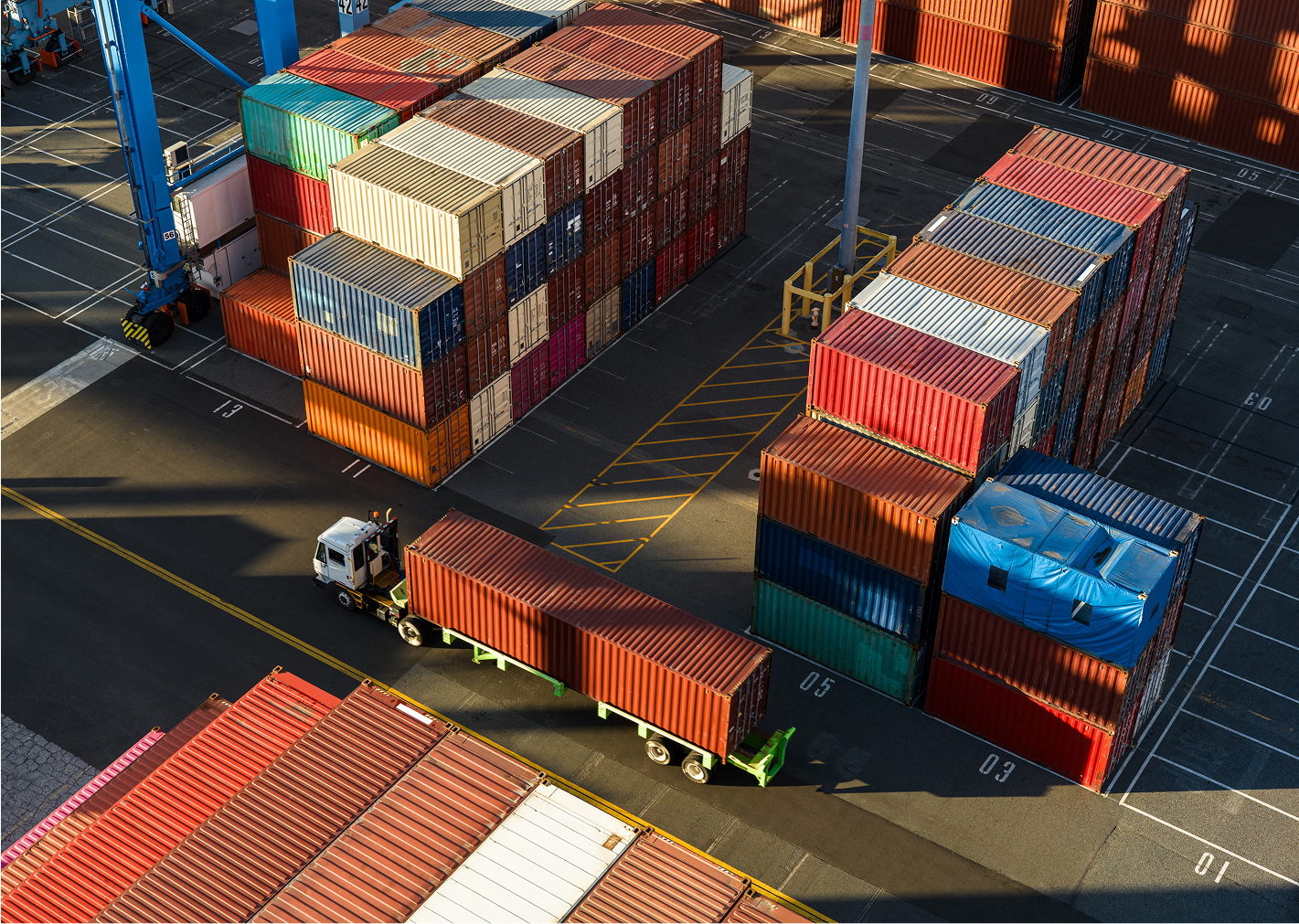 Shipping containers and truck at port terminal.
