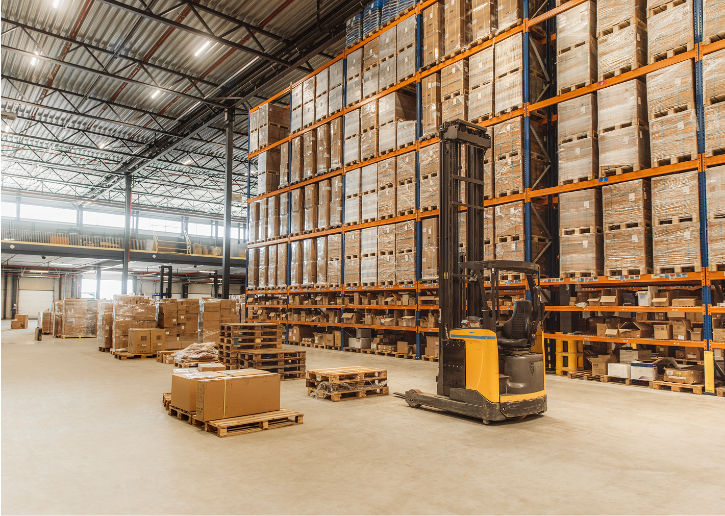Warehouse with stacked pallets and forklift.