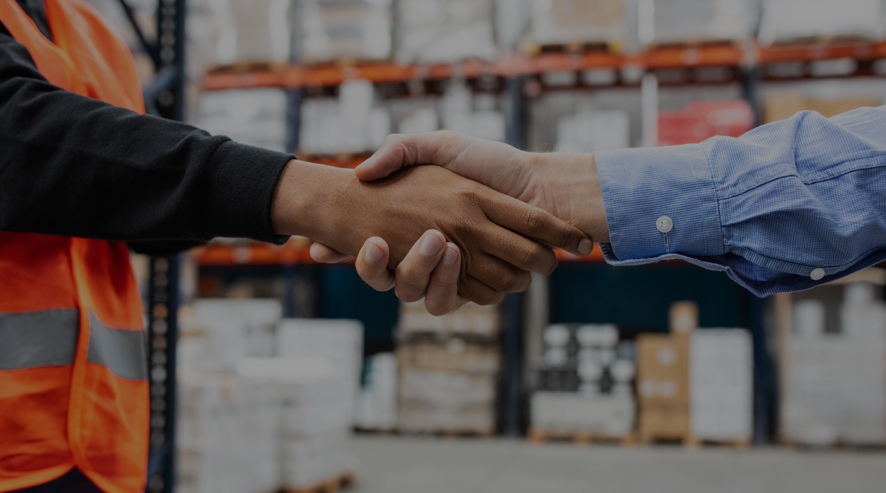 Handshake in a warehouse setting.