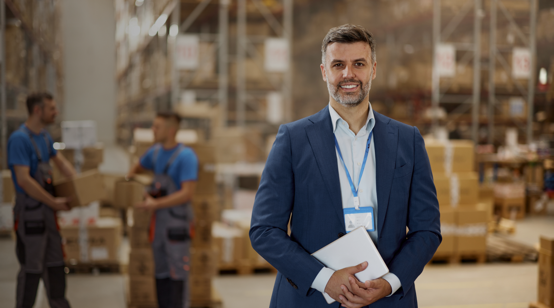 Man in warehouse holding a tablet.