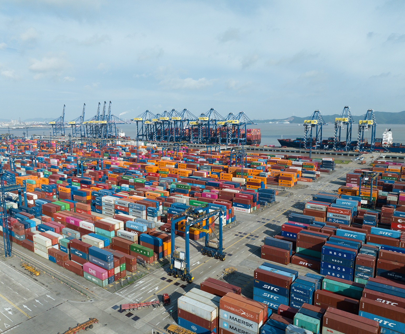Shipping containers stacked at a busy port.